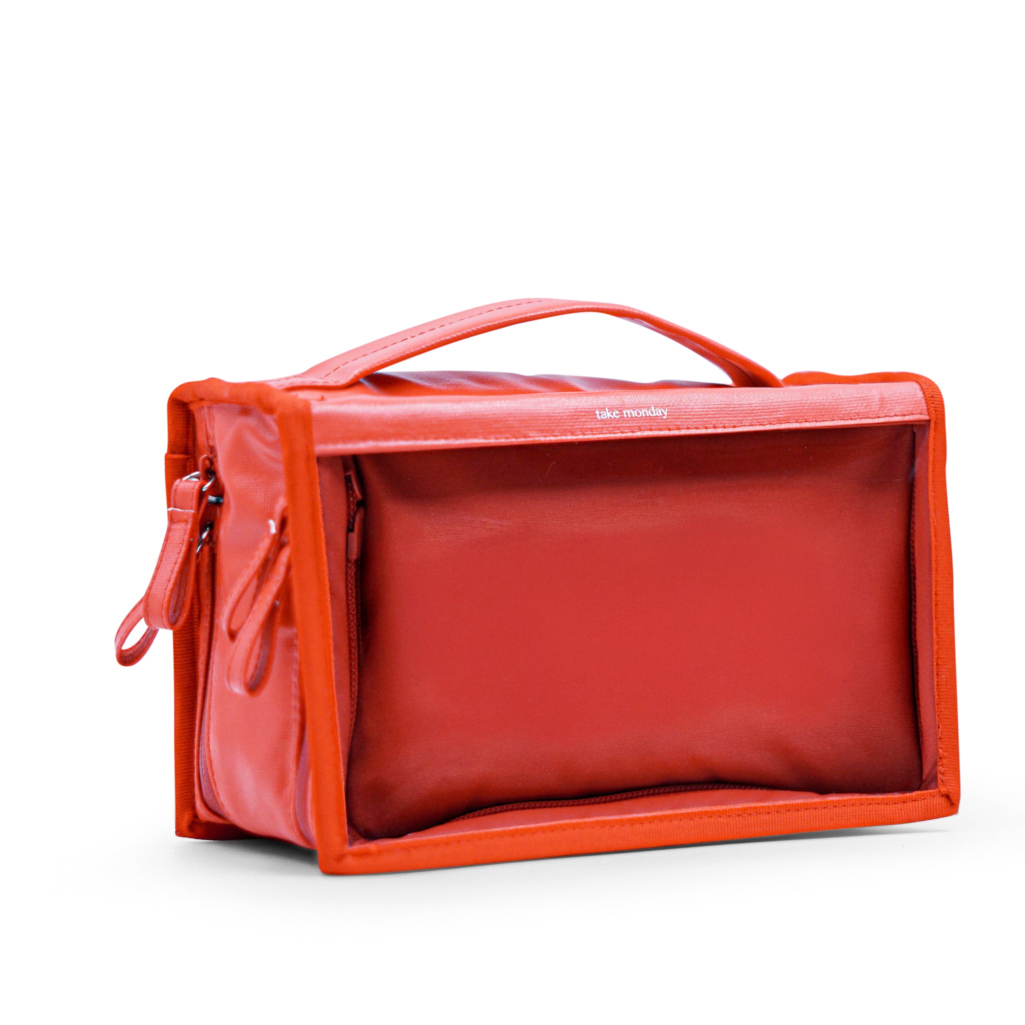 Product photograph of a vibrant orange-red "take monday" rectangular bag with a structured top handle and zippered compartment against a clean white background